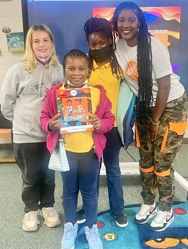 Iesha Smith poses for a picture with three children on her book tour