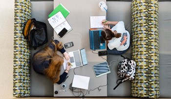 Aerial view of students using various electronic devices to complete coursework