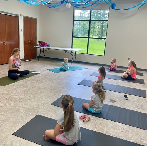A yoga instructor leads children in yoga