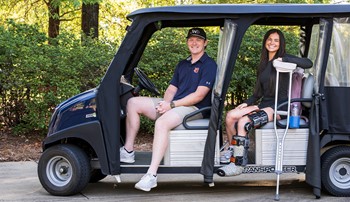 Kendal, on crutches, and Jack sitting in the jAUnt golf cart