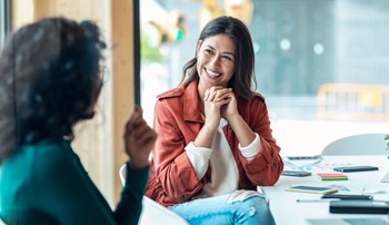 Coworkers talking in a brightly lit office