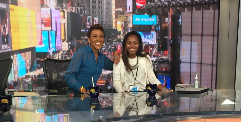 Tiffany Watson sitting next to Robin Roberts on the set of Good Morning America