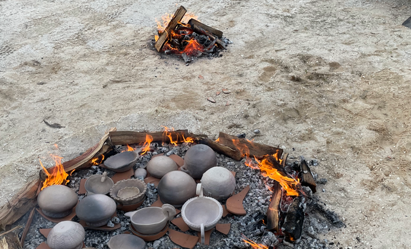 Image of clay pots inside of a bed of coals