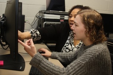 Student and teacher working on a computer