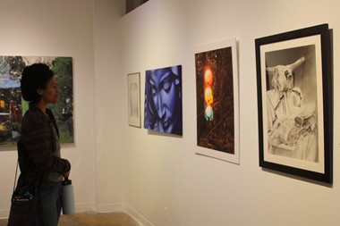 Woman looking at student works in the gallery