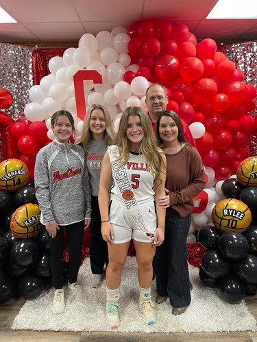 Sophie Willis and her family stand in front of a balloon arch as they celebrate Senior Night
