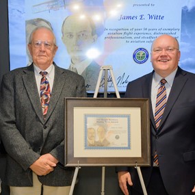 James Witte stands with Auburn leadership and a framed Wright Brothers award