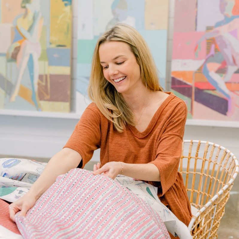 Teil Duncan Henley smiles at a textile collaboration piece in her art studio