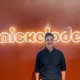 Caleb Eason stands in front of a neon NICKELODEON sign