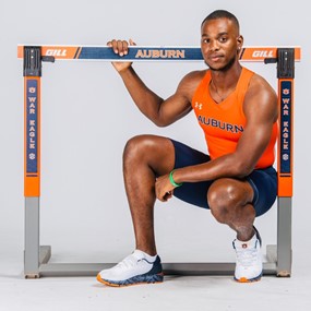 Oquendo Bernard poses with a hurdle in an Auburn track and field uniform