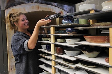 Woman arranging pottery waiting for the kiln