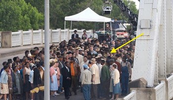 An yellow arrow points to Lowery McNeal in a crowd of extras filming Selma on the Edmund Pettus Bridge