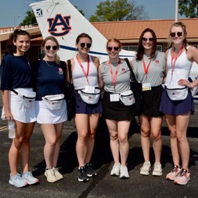 The War Eagle Women stand in front of an Auburn plane during the 2022 Air Race Classic