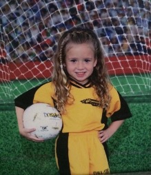 Ashleigh Avallone at the age of three, holding a soccer ball and wearing a soccer uniform