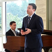 man singing in front of accompanist on piano
